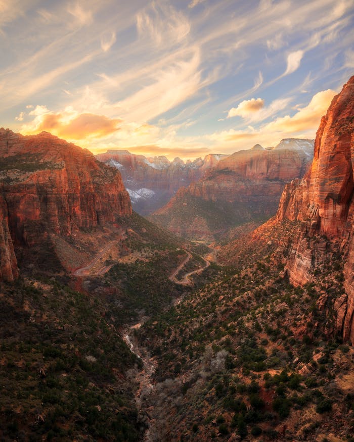 Dramatic sunset over the sandstone cliffs of Zion National Park, capturing the stunning geological formations.